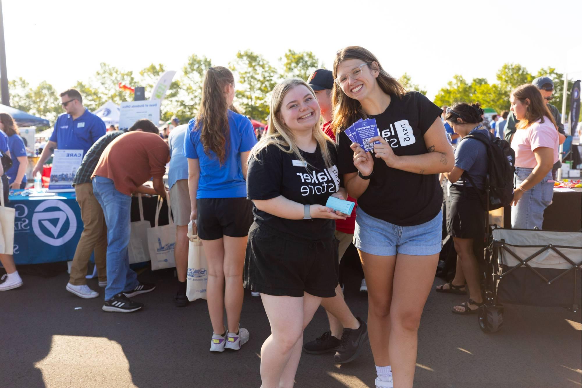 Student worker welcomes student to the event and hands them a water bottle